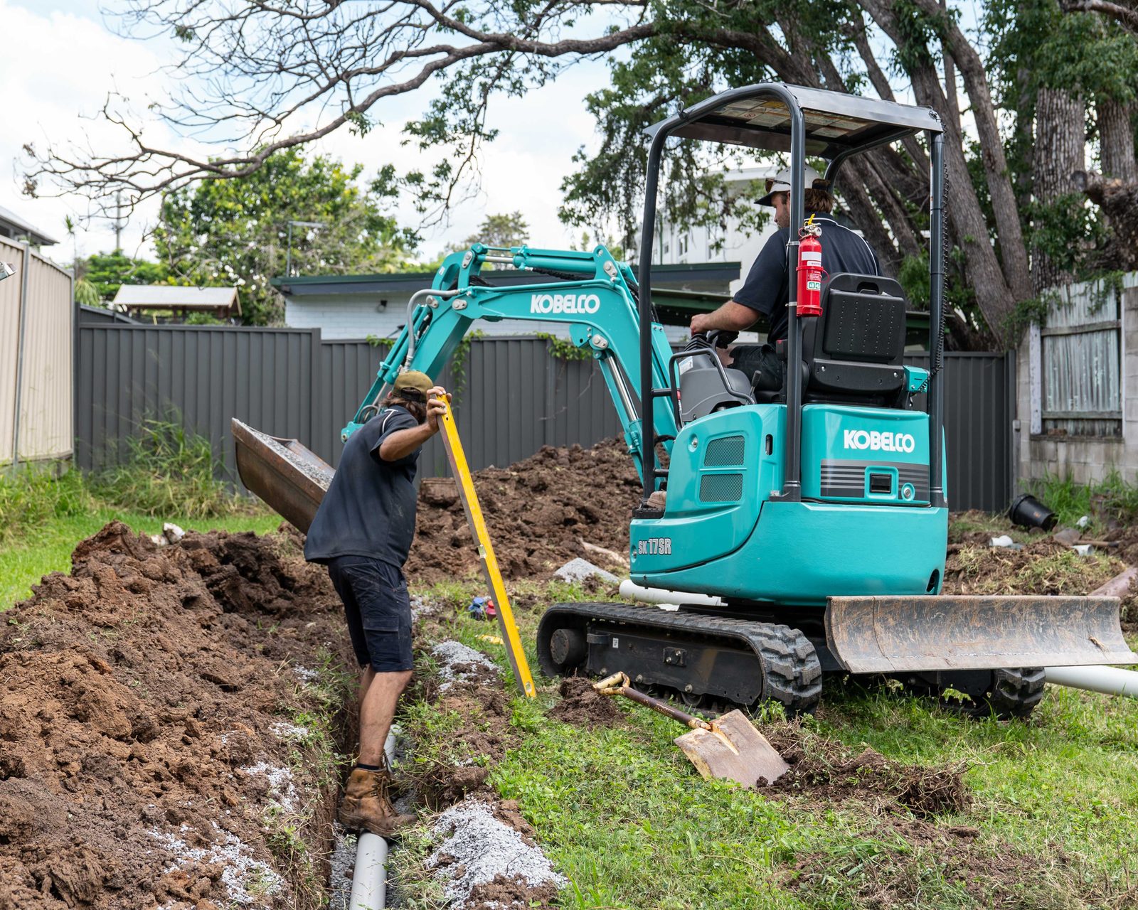 The Goanna Plumbing mini excavator digging a drainage trench