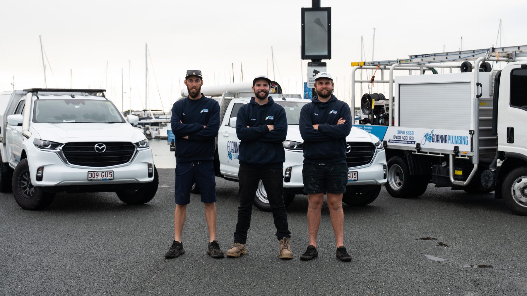 Jessy, Jarred and Tim with the Goanna Plumbing vehicles at Manly Harbour